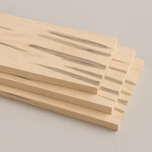 Stack of ambrosia maple lumber boards with pale maple color and gray streaks on a neutral gray background at G&H Hardwoods in Auburn, WA