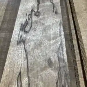 Close-up of a figured black limba hardwood board with dark streaks and swirling grain at G&H Hardwoods in Auburn, WA
