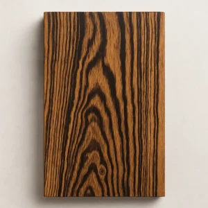 Close-up of a Bocote hardwood board showing golden-brown heartwood with bold dark streaks and dramatic grain figure.