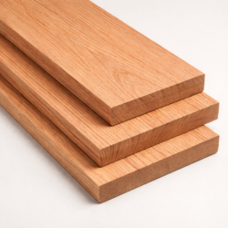 Stack of red oak lumber boards with visible straight grain against a neutral background
