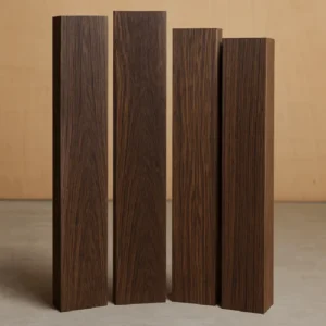 Four vertical Wenge hardwood lumber boards with rich dark grain standing on a concrete floor in the G&H Hardwoods showroom